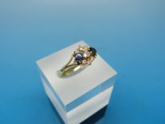An 18ct gold ring set with diamonds and sapphires in a cluster