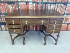 A leather inset oak twin pedestal desk raised on six legs united by cross stretchers in the William
