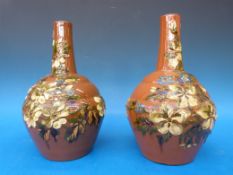 A pair of Exeter Devon Pottery vases relief decorated on a brown ground
