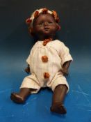 A German bisque headed black baby doll with fixed brown eyes, closed mouth and jointed limbs,