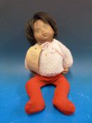 A 1960s Sasha doll of a baby with painted features, shot black hair and jointed limbs,