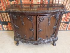 A late 19th or early 20th century cupboard, with shaped front and sides,