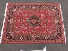 A group of seven near matching carpets and rugs on red ground (largest 281 x 201cm,