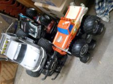 A collection of large scale model monster trucks, some battery operated.