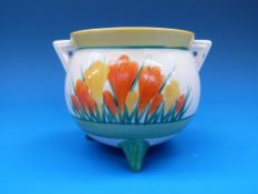 A Clarice Cliff sugar bowl raised on three pointed feet and with pierced triangular handles,