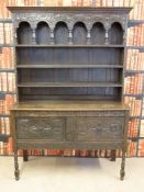 A carved oak dresser with plate rack above (W137, D47,