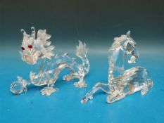 Two Swarovski crystal mythical creatures, a unicorn and a dragon.