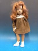 A 1967 Sasha doll of a girl with painted features, long red hair and jointed limbs,