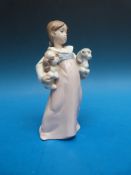 A Lladro figurine of a girl with two puppies 