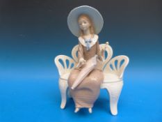 A large Lladro figurine of a lady on a bench (26cm tall)