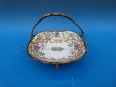 An Ormolu mounted ceramic basket with enamelled botanical decoration