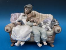 A Lladro figurine of girls on a sofa with a puppy 