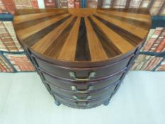A small reproduction D-shaped cabinet with four central drawers flanked by two banks of smaller