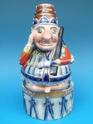 An unusual Staffordshire figure from Punch and Judy modelled with Punch astride a drum entitled