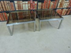 A pair of stainless steel glass-topped coffee tables