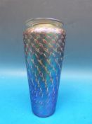 An iridescent glass vase with repeated spiral decoration and flared rim.