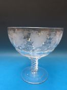 A pedestal glass punch bowl engraved to the body with grapes and vines raised on air twist stem