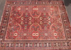 A wool rug with all over floral design on a red ground (425 x 330 cm)