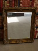 An ornate bevelled glass wall mirror (78.
