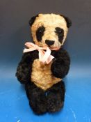 A vintage panda bear with jointed limbs probably Merrythought or Chiltern Hygienic Toys, 36cm tall.