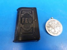 A white metal medallion named F.