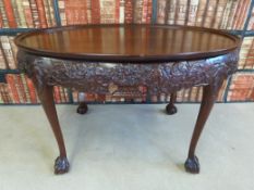An oval tray top occasional or sidetable with carved decoration to the shaped frieze,