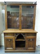 A Victorian oak Gothic bookcase, the top having glazed doors and adjustable shelves,