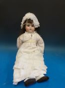 A German bisque headed doll with open mouth, weighted blue eyes and long brown hair.