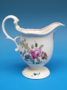 An 18thC Liverpool helmet-shaped pedestal cream jug painted in coloured enamels with flowers and