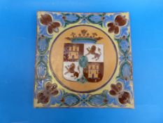 A Iarge Arts and Crafts Armorial tile with foliate border (30cm x 30.