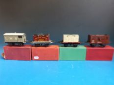 Four Hornby 0 gauge trucks, vans and wagons, an LMS brake van, a No 50 low-sided wagon,