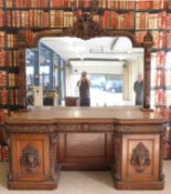 A large heavily carved 19th century oak twin pedestal inverted break front mirror backed side board,