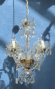 A pair of glass four branch chandeliers with etched sconces and brass mounts.