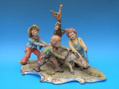 A Capodimonte figural group of children in a playground with a donkey (26cm high)