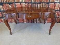 A Louis XV style kingwood desk having three drawers raised on shaped legs with gilt mounts and