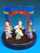 A Bronte Porcelain Punch and Judy set of six candle snuffers on stand and surround.