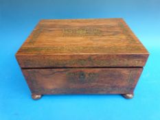 A brass inlaid rosewood work box raised on bun feet and with fitted interior,