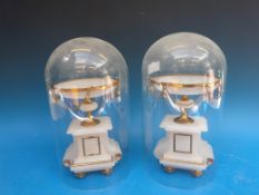 A pair of alabaster garnitures under glass domes