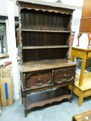 An oak dresser with plate rack top the base with cupboard and shelf below (W107, D42,