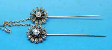 Two matching yellow metal pins,