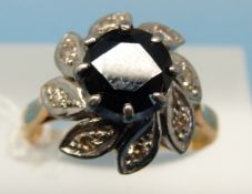An 18ct gold ring set with a large central sapphire surrounded by diamonds in a platinum setting