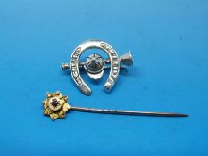A 9ct gold stick pin set with a ruby and a silver brooch in the form of a horseshoe