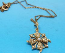 A yellow metal pendant marked 15ct set with seed pearls in a floral design