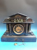 A Victorian slate mantel clock with marbled decoration in Romanesque style,