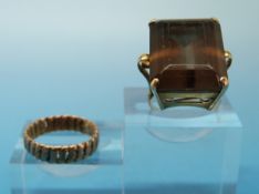 A yellow metal ring set with a large smoky quartz and yellow metal ring
