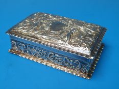 A repousee decorated hallmarked silver box with vacant cartouche and gilt interior,
