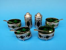 A hallmarked silver Art Nouveau six piece cruet set with pierced mounts showing green glass liners,