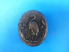 A Japanese bronze brooch depicting a stork amongst reeds
