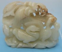 A white celadon jade carving of geese standing upon a rocky outcrop with various small russet