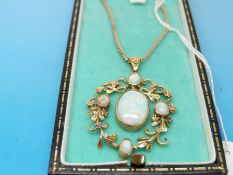 A yellow metal pendant with a large oval opal to the centre surrounded by a scrolling foliate